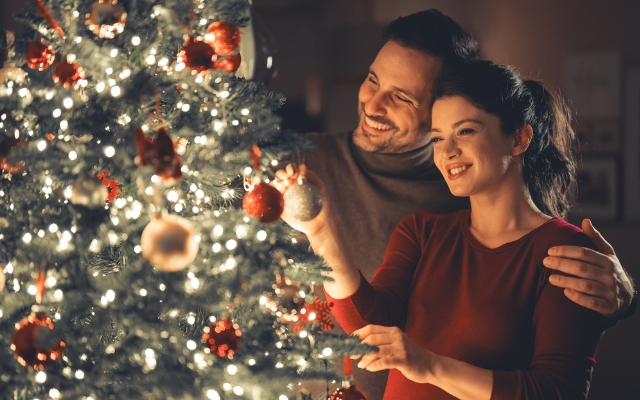 Husband and wife decorating the Christmas tree