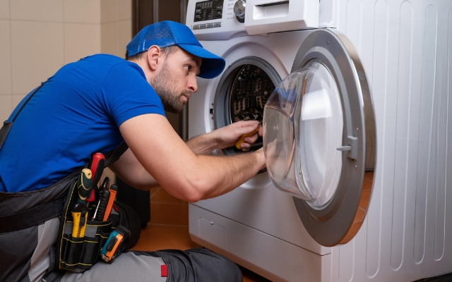 Repair man repairing a dryer