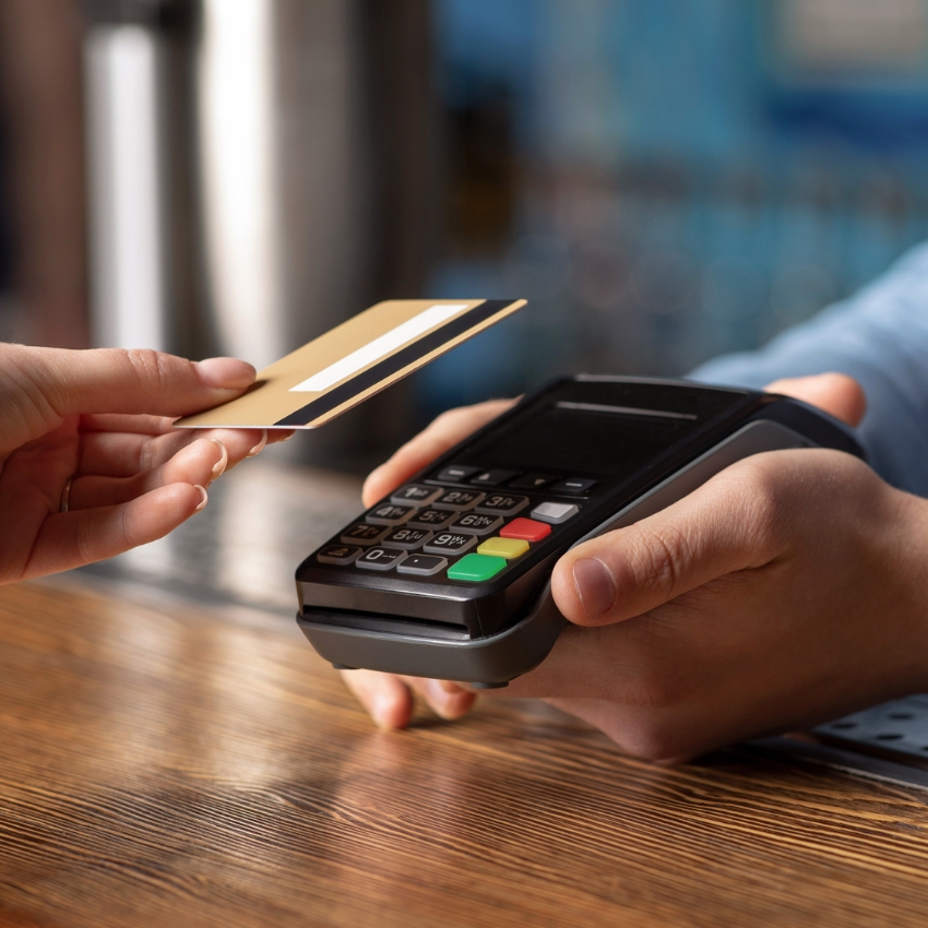 close-up of a woman holding a card over a card reader